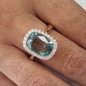 18ct rose gold statement ring featuring Green-blue cushion cut aquamarine with diamond halo.